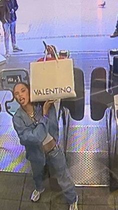 a woman holding up a cardboard box with the word valentine on it