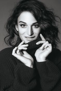 a black and white photo of a woman with her hands on her face, posing for the camera