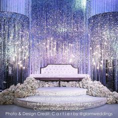 the stage is decorated with white flowers and silver sequins for an elegant wedding