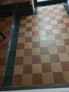 a bathroom floor that has been tiled with different colors and patterns on it, next to a window