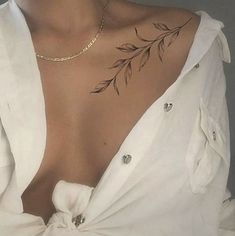 a woman with a flower tattoo on her chest and shoulder, wearing a white shirt