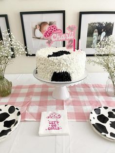 a birthday cake with black and white frosting sitting on top of a checkered table cloth