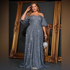 a woman standing in front of a mirror wearing a blue dress with sequins