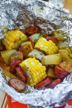 corn on the cob and sausage wrapped in foil