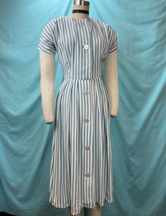 1940s/1950s W:24" Vintage 40s 50s dress mint stripe cold rayon short sleeve button up mother of pearl  Stunning vintage 40s/50s. Beautiful summer classic in cold rayon with diagonal print of a stripes in white and blue/mint color. Short sleeve with scoop neckline with fitted bodice and A-line skirt with side pleats. Dress is button up and opens up fully with a row of button in mother of pearl in the middle. Unlined. Photographed on fitting form size 2, check measurements.  MEASUREMENTS  Bust: 32 Striped Short Sleeve Dress With Buttons, Fitted Dress With Vertical Stripes And Short Sleeves, Fitted Short Sleeve Dress With Vertical Stripes, 1950s Short Sleeve Lined Vintage Dress, 1940s Maternity Fashion, Short Sleeve Vintage Dress With Button Closure, Vintage Short Sleeve Striped Dress, 1940s Wrap Dress, 1940s Utility Dress