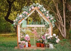 a small wooden house with potted plants and flowers