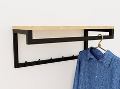 a blue shirt hanging on a clothes rack with a coat hanger attached to it