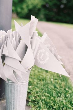 a trash can filled with papers sitting on the side of a road