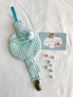 a baby pacifier and bib laying next to it's contents on a white sheet