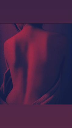 the back of a woman's body with red light coming from behind her,