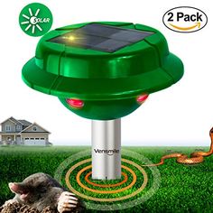 an animal laying on top of a lush green field next to a solar powered lamp