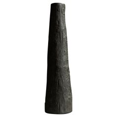 a tall black vase sitting on top of a table