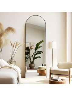 a living room with a couch, chair and large mirror