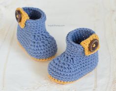 a pair of blue crocheted baby shoes with buttons