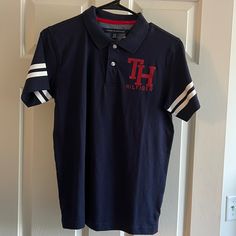 Brand New Tommy Hilfiger Polo Style Shirt. Boys 16/18 Tommy Hilfiger Navy Short Sleeve Top, Tommy Hilfiger Navy Sporty Tops, Casual Navy Tommy Hilfiger Top, Blue Sporty Tommy Hilfiger Tops, Sporty Blue Tommy Hilfiger Top, Tommy Shirt, Boys 16, Tommy Hilfiger Baby, Red Polo Shirt