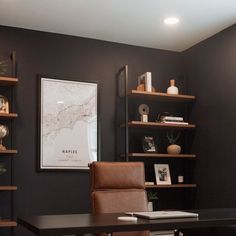 a desk and chair in a room with shelves on the wall