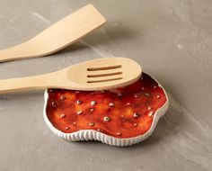 two wooden utensils sitting next to each other on top of a countertop