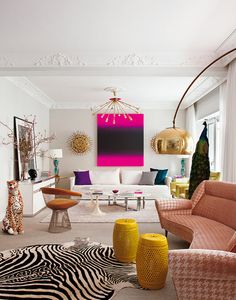 a living room filled with lots of furniture and colorful art on the wall above it