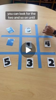 someone is playing a game on the table with numbers and squares in front of them