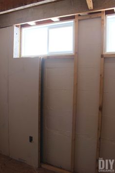 an unfinished room with two windows in the wall and no insulation on the floor,