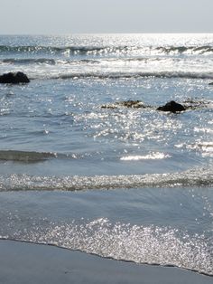 the sun shines on the water at the beach