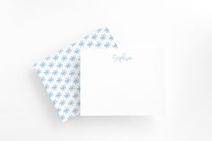 two folded note cards on top of each other with blue and white flowers printed on them