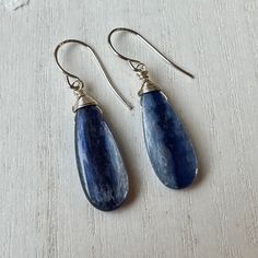 These kyanite teardrop briolette beads are a fantastic medium blue color with terrific sheen.  I gave them a wrapped sterling silver top and suspended them on my handmade sterling silver hook ear wires.  These earrings are 1 5/8 inches long from the top of the hook. Here's an entrance to my shop - http://www.etsy.com/shop/TheTwistedPretzel Blue Gemstone Teardrop Earrings, Sterling Silver Teardrop Earrings With Natural Stones, Blue Lapis Lazuli Teardrop Earrings, Blue Teardrop Lapis Lazuli Earrings, Blue Briolette Teardrop Earrings For Gift, Everyday Blue Earrings With Natural Stones, Handmade Blue Pear-shaped Jewelry, Handmade Blue Teardrop Sterling Silver Earrings, Everyday Blue Dangle Teardrop Earrings