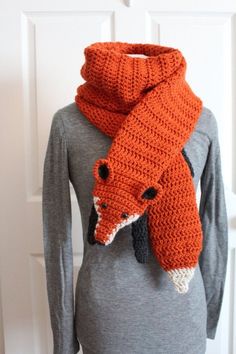 an orange knitted scarf hanging on a mannequin's dummy wearing a gray shirt