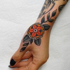 a woman's hand with a flower tattoo on it