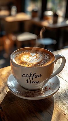 a cup of coffee sitting on top of a wooden table