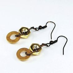 pair of gold and black metal earrings on white background with clipping for ear wires