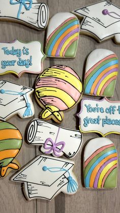 decorated cookies with graduation caps and diplomas are on a wooden table next to some writing