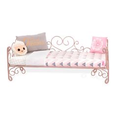 a pink metal day bed with pillows and a stuffed animal