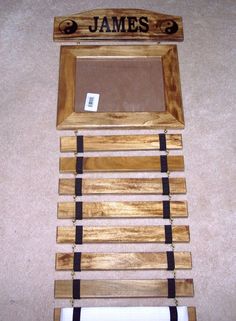 a wooden frame with the name james written on it and some black straps hanging from it