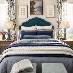 a bedroom with blue and white bedding in front of two pictures on the wall