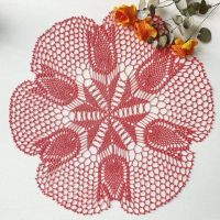 a red doily sitting on top of a white table next to some orange flowers