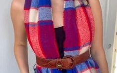 a woman wearing a red, blue and white plaid scarf with a brown belt around her waist