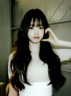 a woman with long black hair is posing for the camera