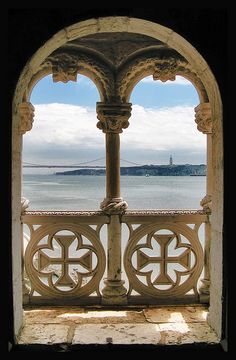 an arched window overlooking the water and bridge