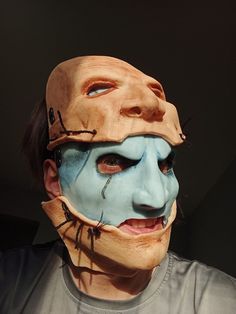 a man with his face painted blue and wearing a mask