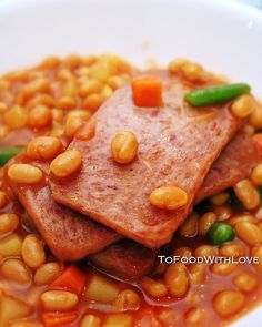 a white plate topped with meat and beans