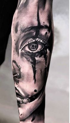 a man's leg with black and white tattoos on it, including an evil face