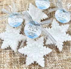 four snowflakes are wrapped in clear cellophane and tied with silver ribbon