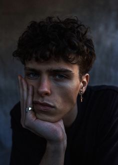 a close up of a person with a ring on their finger and her hand near her face