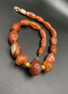 The Rare Unique PEMA RAKA Carnelian Amulet Prayer Beads Necklace From Himalayan Tibet The Age Of This Beads Are More than 1000 years Old As You Can See From Its Conditions Very Oily Smooth Skin Of This Pema Beads Some Gold Plated Wax and Gold Color Brass Beads Are Used As Spacers Rare Items For Collections Carnelian Amulet Jewelry With Round Beads, Traditional Carnelian Gemstone Beads, Spiritual Carnelian Oval Beads Jewelry, Artisan Amber Gemstone Beads And Cabochons, Spiritual Oval Carnelian Bead Jewelry, Hand-strung Amber Amulet Jewelry, Amber Hand-strung Amulet Jewelry, Artisan Hand-strung Carnelian Beads, Artisan Carnelian Beads For Jewelry Making