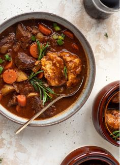 a bowl of stew with meat, carrots and potatoes