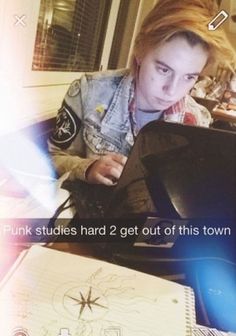 a young man sitting at a table with a laptop computer in front of him and the caption reads punk studies hard 2 get out of this town