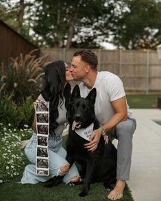 a man and woman kissing their dog in the backyard