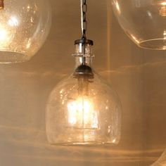 three clear glass lights hanging from a ceiling