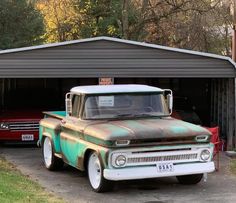 an old truck parked in front of a garage